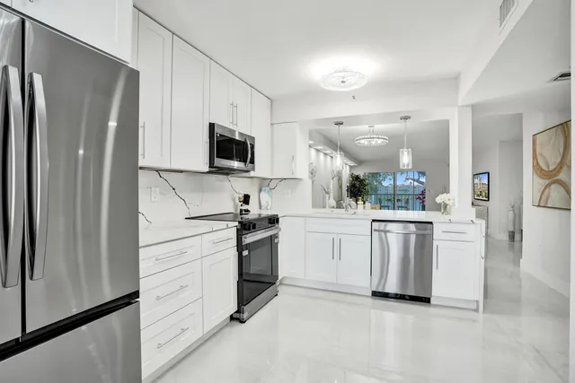 a kitchen with cabinets stainless steel appliances and a counter space