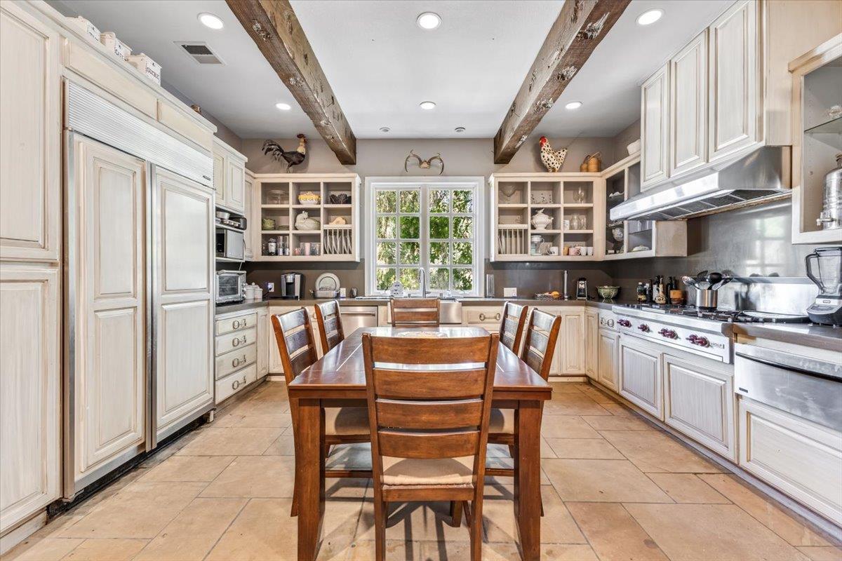 2727 Thomas Road Hollister, CA 95023 - Photo 16 of 83 a kitchen with stainless steel appliances granite countertop a stove top oven a sink a dining table and chairs with wooden floor