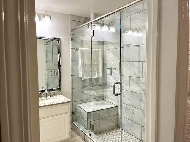 a bathroom with a shower and a sink