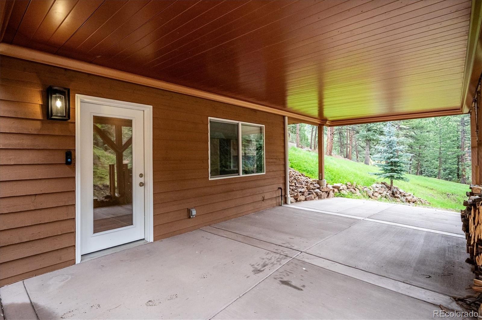 6747 South Brook Forest Road Evergreen, CO 80439 - Photo 36 of 49 a view of a house with a porch and wooden floor