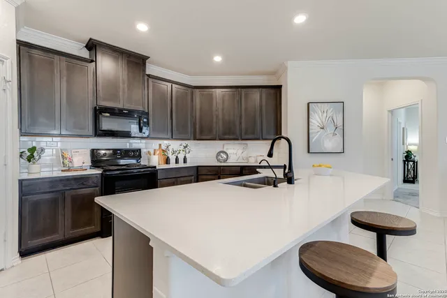 a kitchen with kitchen island granite countertop a sink stainless steel appliances and cabinets
