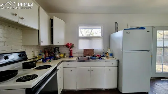 a kitchen with sink a refrigerator and cabinets