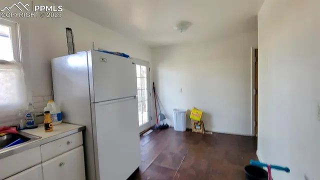 a view of a kitchen with a sink and refrigerator