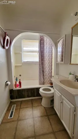 a bathroom with a toilet sink vanity granite and mirror