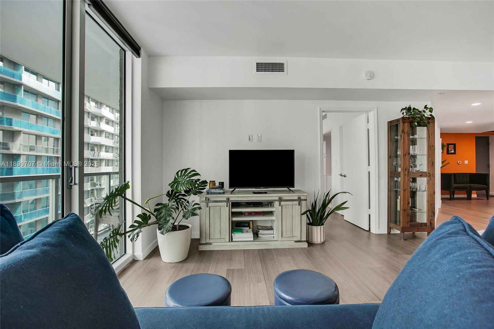 55 Southeast 6th Street, Unit 3701 Miami, FL 33131 - Photo 2 of 21 a living room with furniture and a flat screen tv