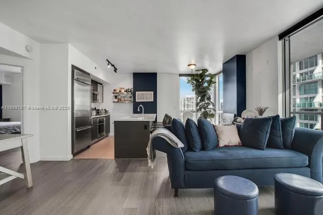 a living room with furniture kitchen view and a potted plant