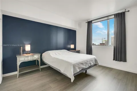 a bedroom with a bed and a large window