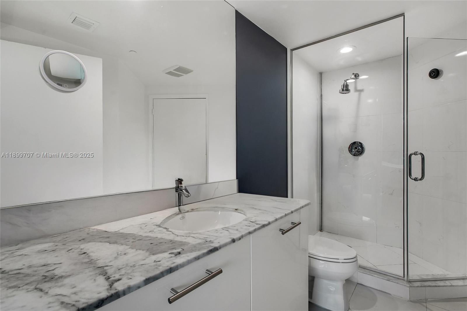 55 Southeast 6th Street, Unit 3701 Miami, FL 33131 - Photo 10 of 21 a bathroom with a granite countertop sink a toilet and shower