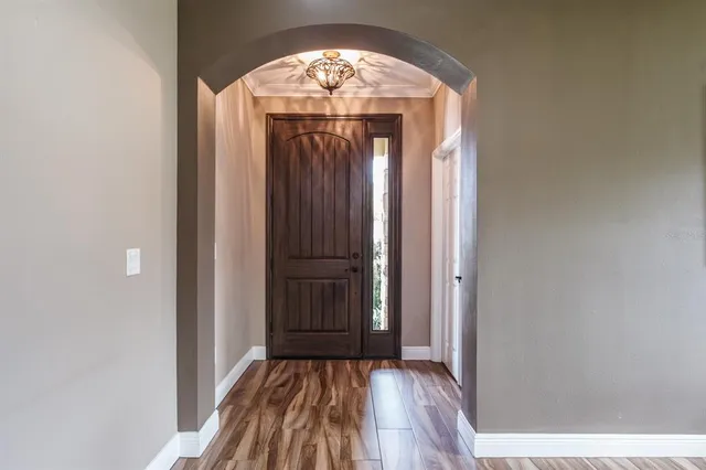 a view of an empty room with wooden floor and closet