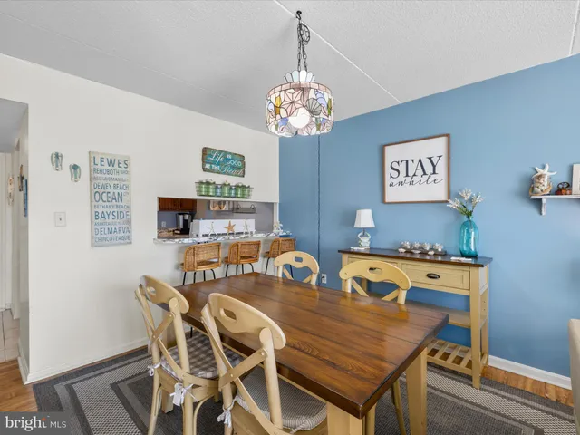 a view of a dining room with furniture a chandelier and wooden floor