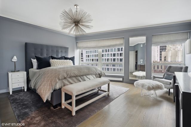 a bedroom with a large bed couch and a large window