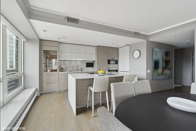 a living room with furniture a rug and kitchen view