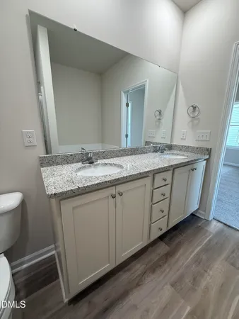 a bathroom with a granite countertop toilet sink and mirror