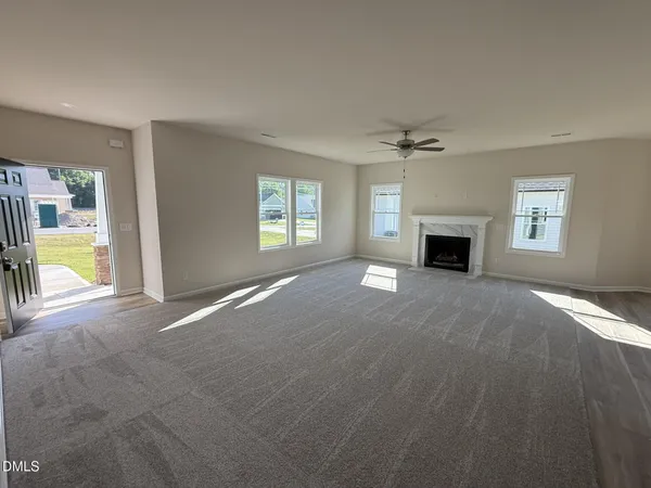 a view of an empty room with a fireplace and a window