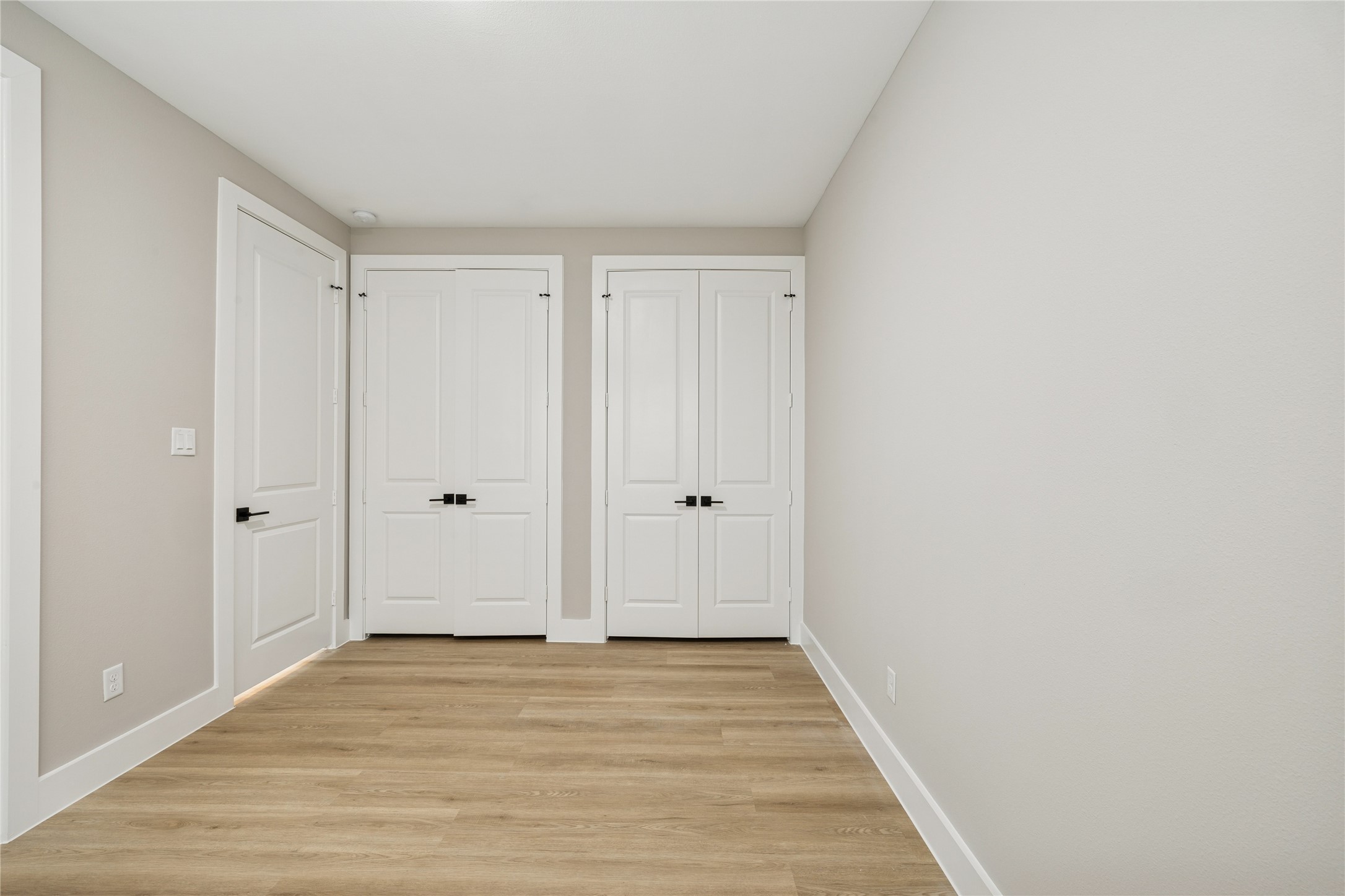 2602 Martinas Ct Spring Spring, TX 77388 - Photo 14 of 24 This room features a clean, modern design with light wood flooring and neutral walls. It includes two white double doors, providing ample closet space or entry to an adjoining room. Bright and minimalist, perfect for customization.
