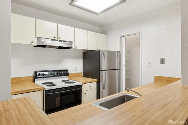 a kitchen with stainless steel appliances granite countertop a refrigerator stove top oven and sink