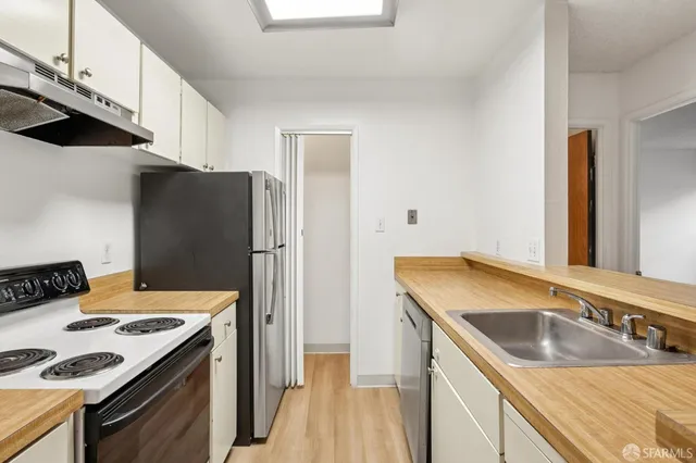 a kitchen that has a sink a stove and refrigerator
