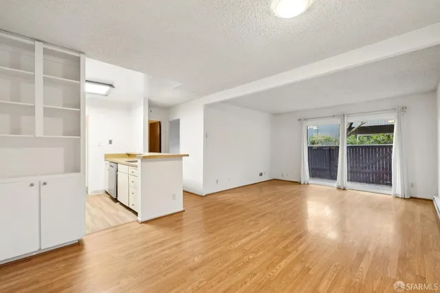 a view of a kitchen with wooden floor and a window