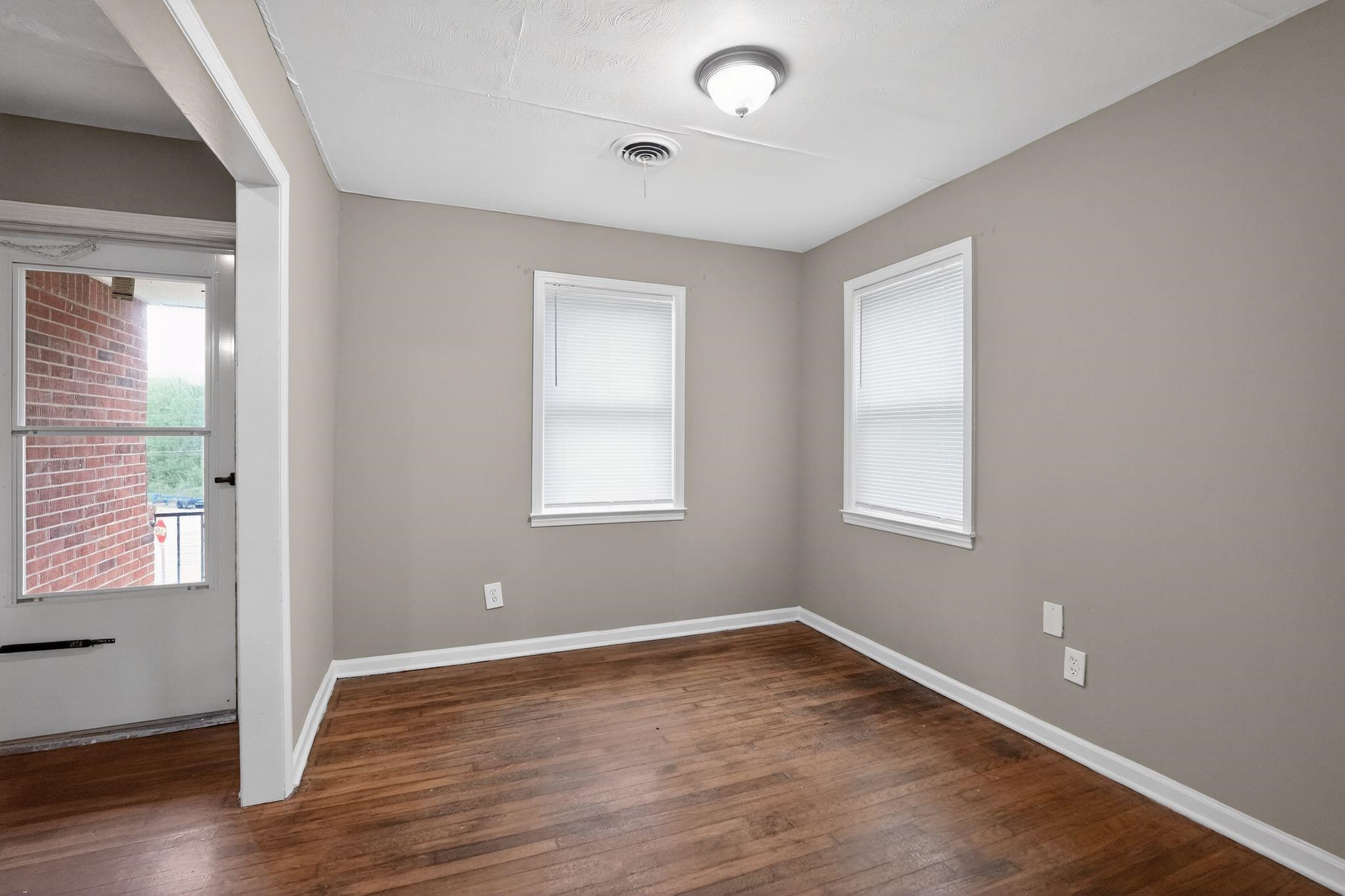 134 West Holmes Road Memphis, TN 38109 - Photo 12 of 30 Empty room with dark wood-style floors and healthy amount of natural light