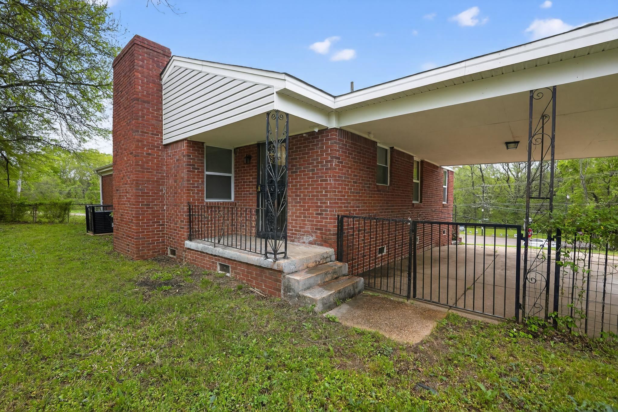 134 West Holmes Road Memphis, TN 38109 - Photo 2 of 30 Property entrance featuring brick siding, a carport, crawl space, and a chimney
