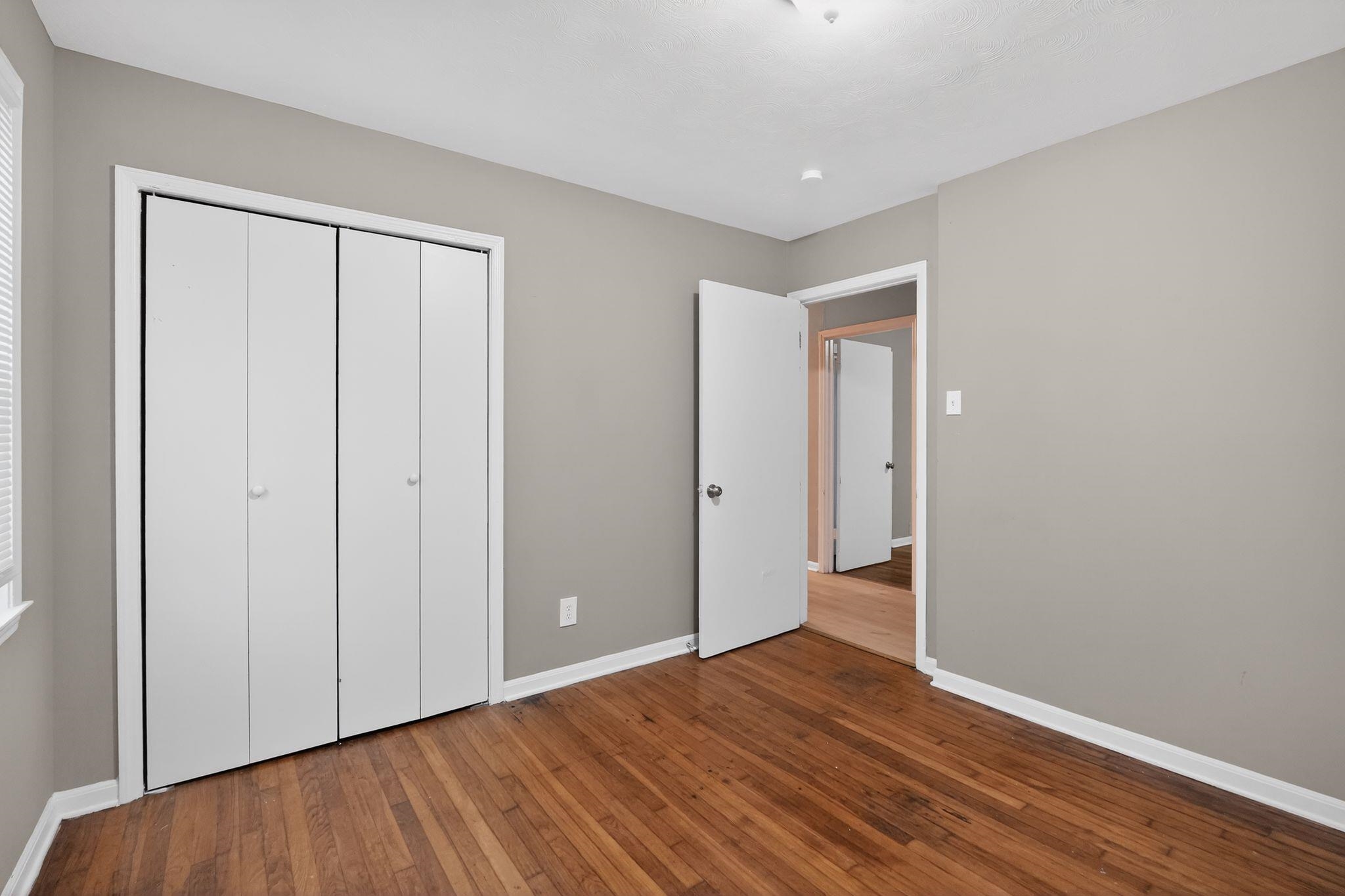 134 West Holmes Road Memphis, TN 38109 - Photo 25 of 30 Unfurnished bedroom featuring dark wood-style floors and a closet