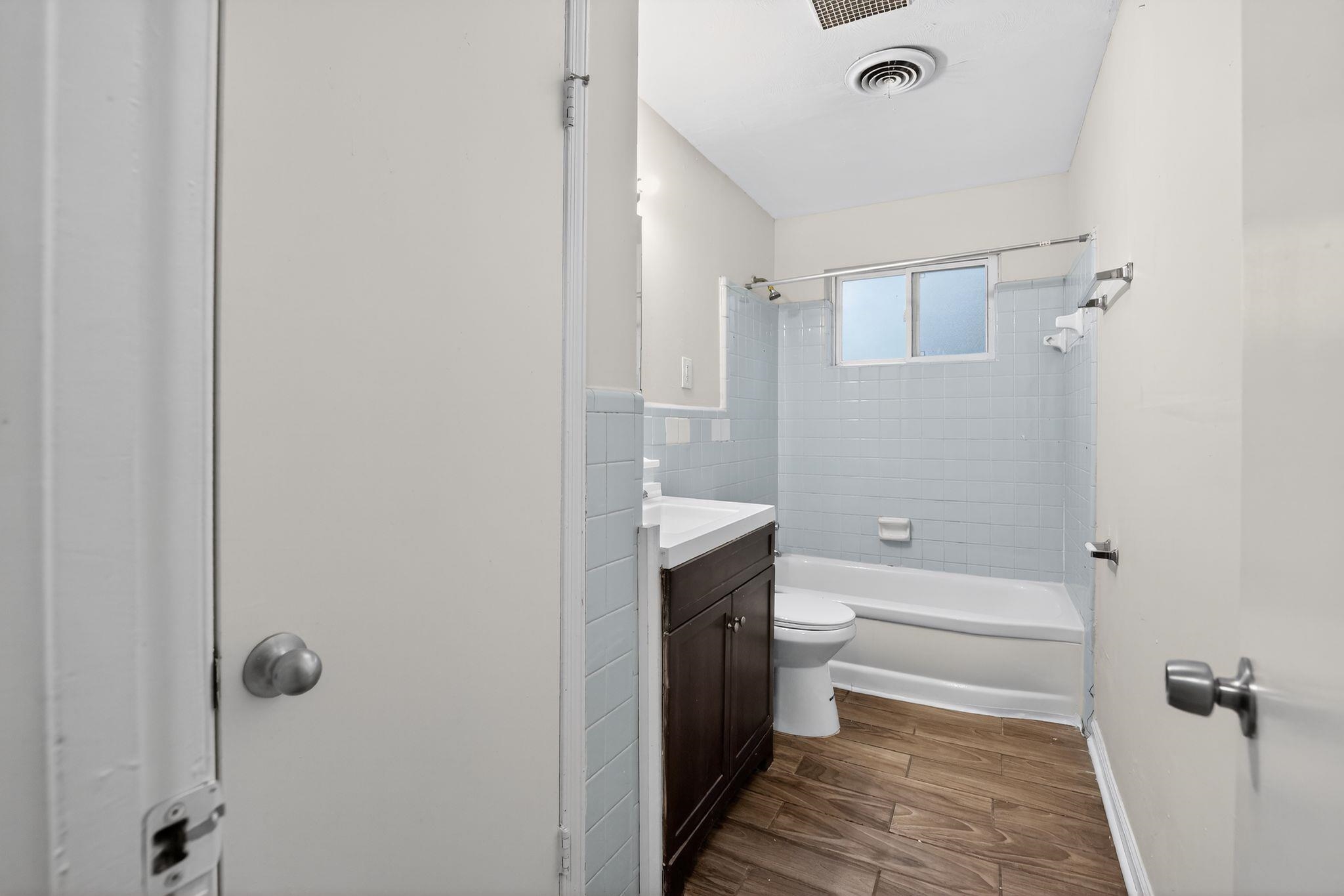 134 West Holmes Road Memphis, TN 38109 - Photo 27 of 30 Full bathroom with dark wood-style flooring, vanity, and tub / shower combination