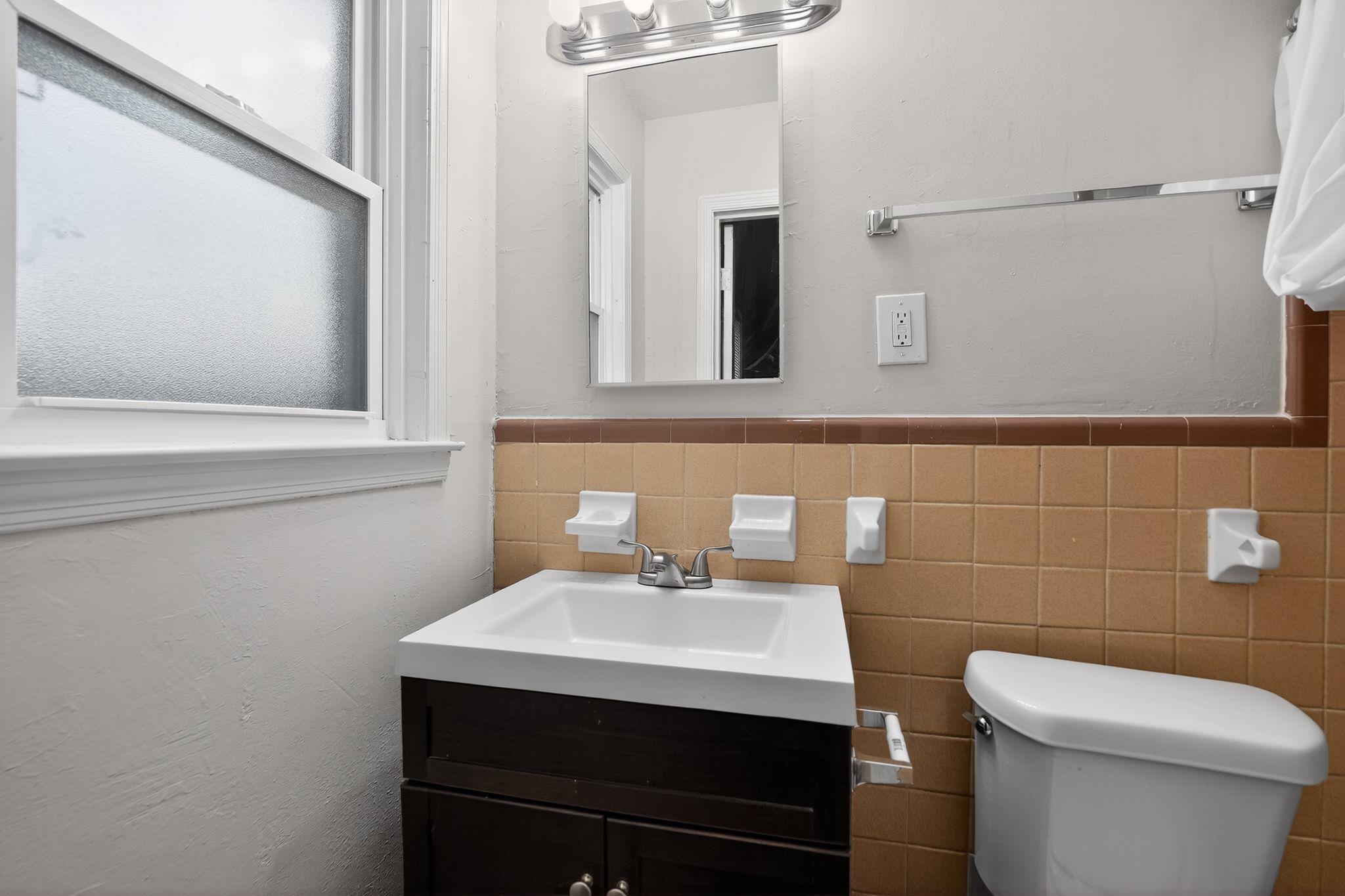 134 West Holmes Road Memphis, TN 38109 - Photo 28 of 30 Bathroom featuring vanity, tile walls, and a wainscoted wall