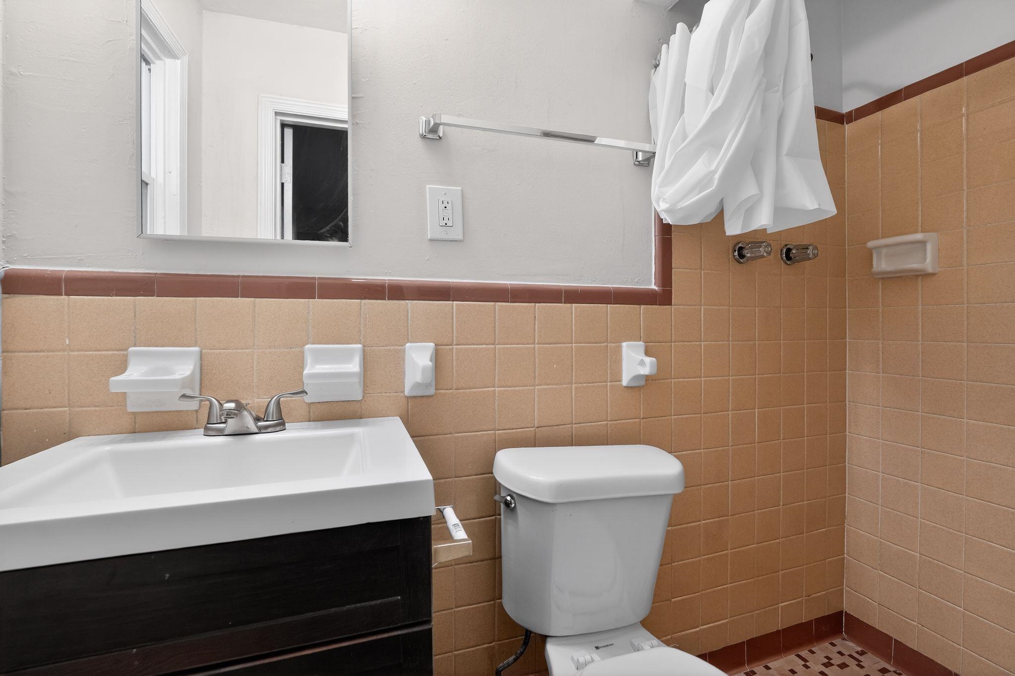 134 West Holmes Road Memphis, TN 38109 - Photo 30 of 30 Full bath featuring vanity, a tile shower, tile walls, and wainscoting
