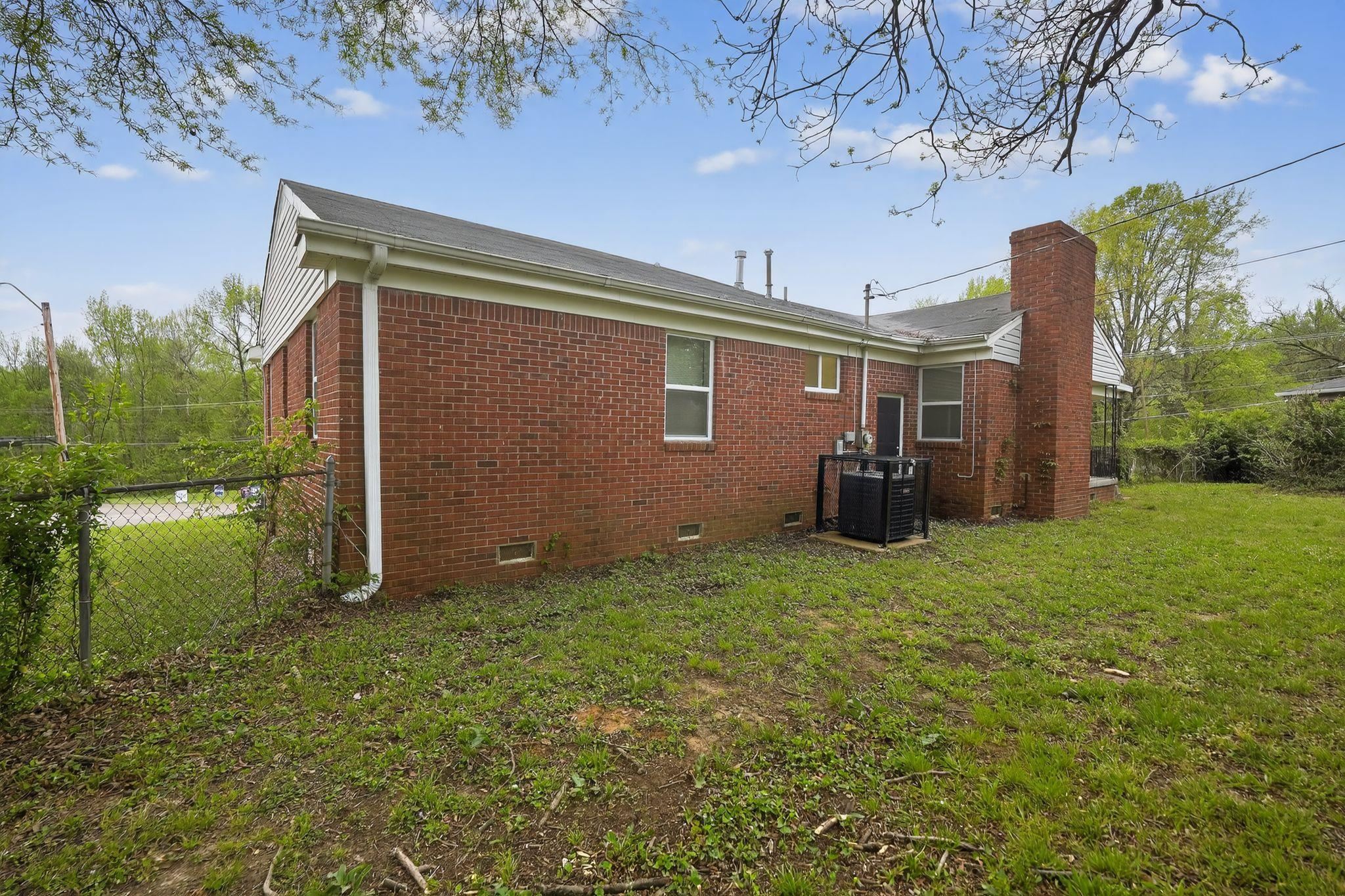 134 West Holmes Road Memphis, TN 38109 - Photo 6 of 30 View of property exterior featuring crawl space, brick siding, and a chimney