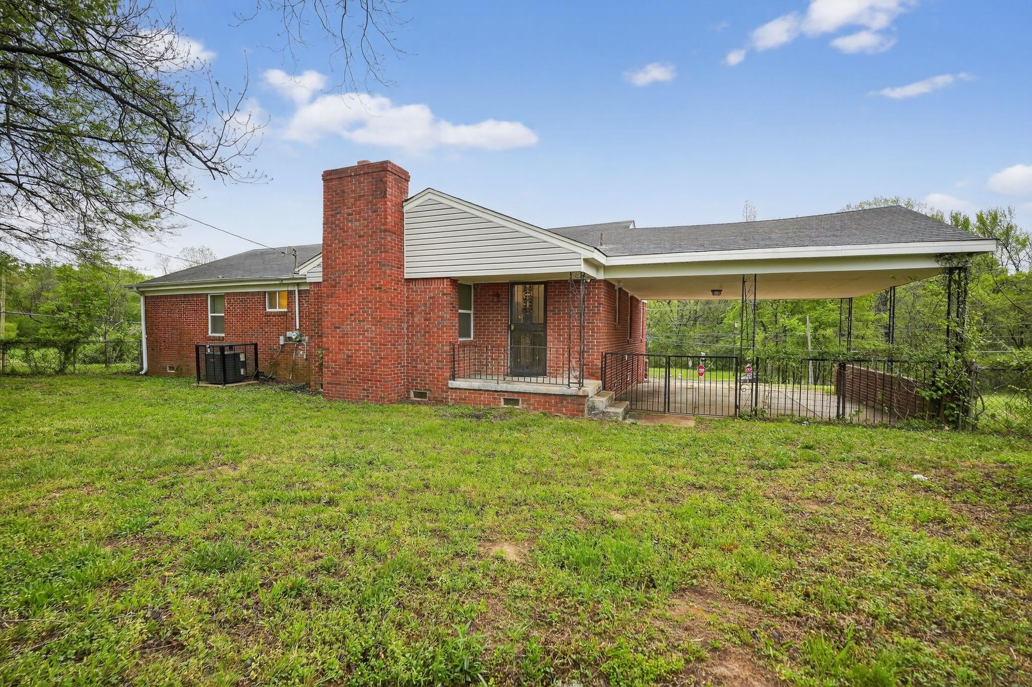 134 West Holmes Road Memphis, TN 38109 - Photo 10 of 30 Back of house featuring a chimney, a lawn, and brick siding