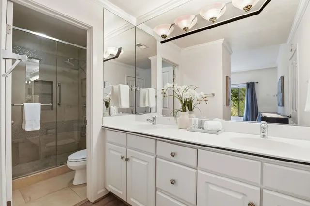 a bathroom with a granite countertop sink a toilet and shower