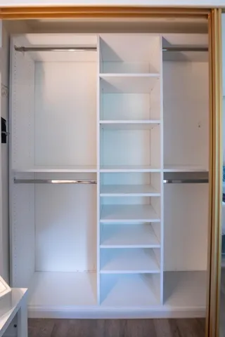 a view of walk in closet with empty racks