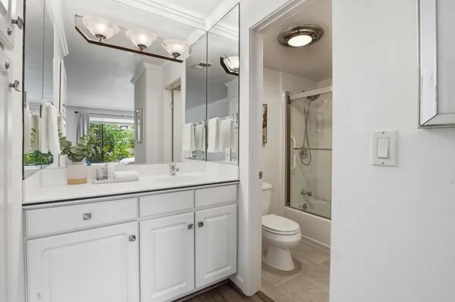 a bathroom with a toilet a sink and a large mirror