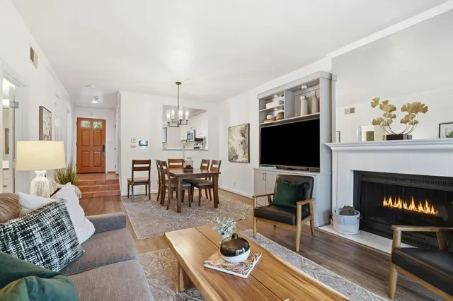 a living room with furniture a flat screen tv and a fireplace