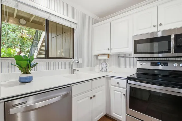 a kitchen with appliances a sink and cabinets