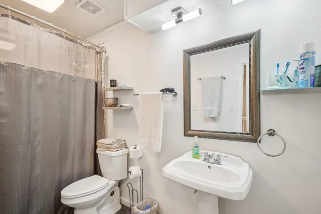 a bathroom with a sink toilet and shower