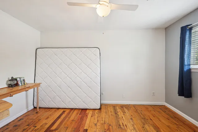 a view of room with wooden floor and fan