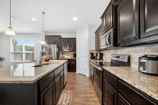 a kitchen with granite countertop stainless steel appliances and wooden cabinets