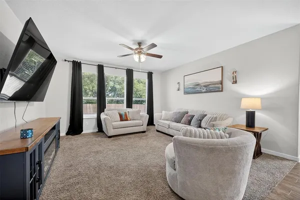 a living room with furniture a flat screen tv and a floor to ceiling window
