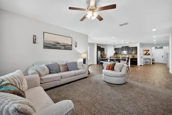 a living room with furniture and kitchen view