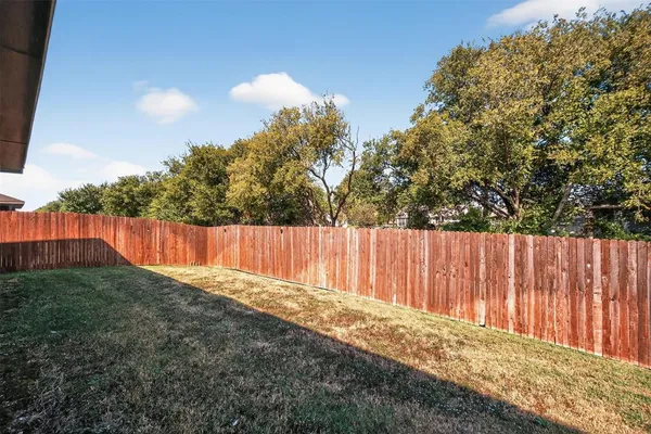 a view of a backyard with wooden fence