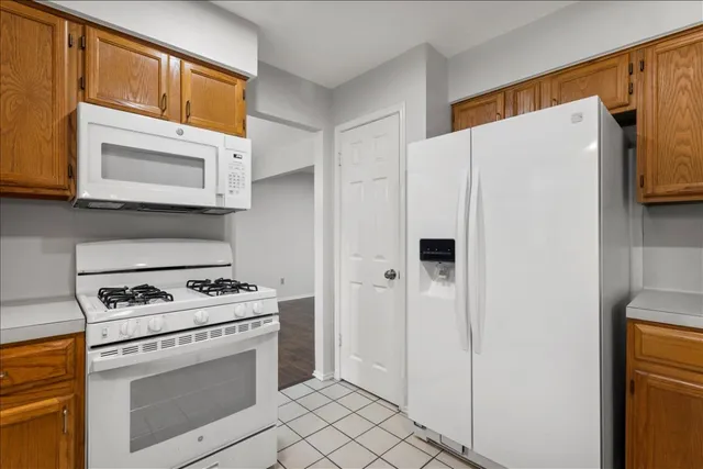 a white refrigerator freezer and a stove sitting inside of a kitchen