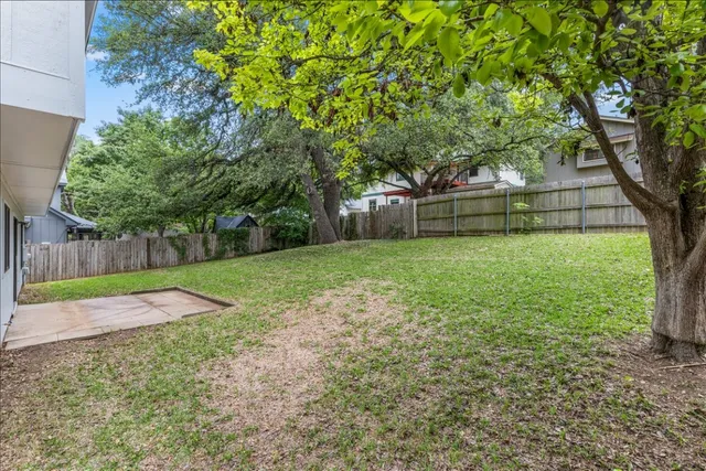 a view of a backyard with large trees