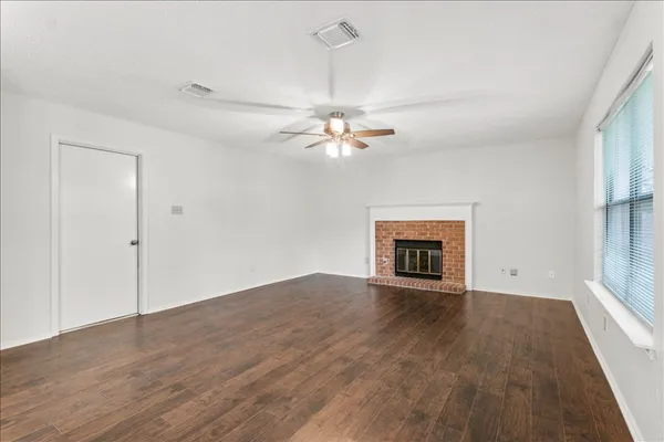 an empty room with fan and windows