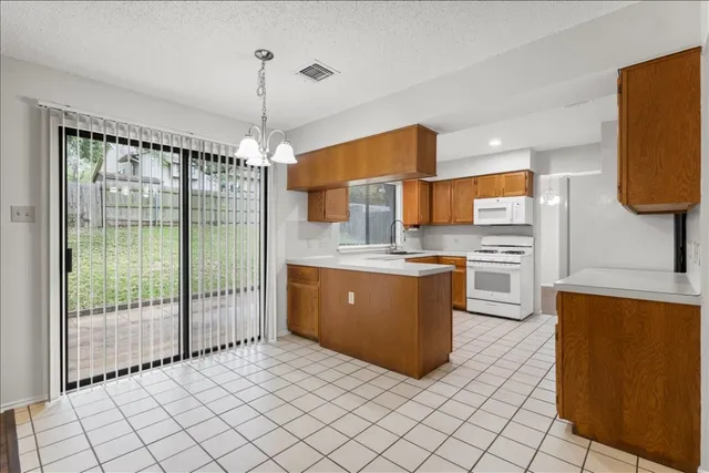 a kitchen with stainless steel appliances granite countertop a stove a sink dishwasher and a refrigerator