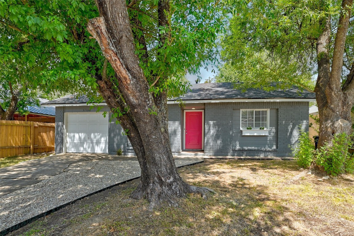 a view of a house with a tree in the yard