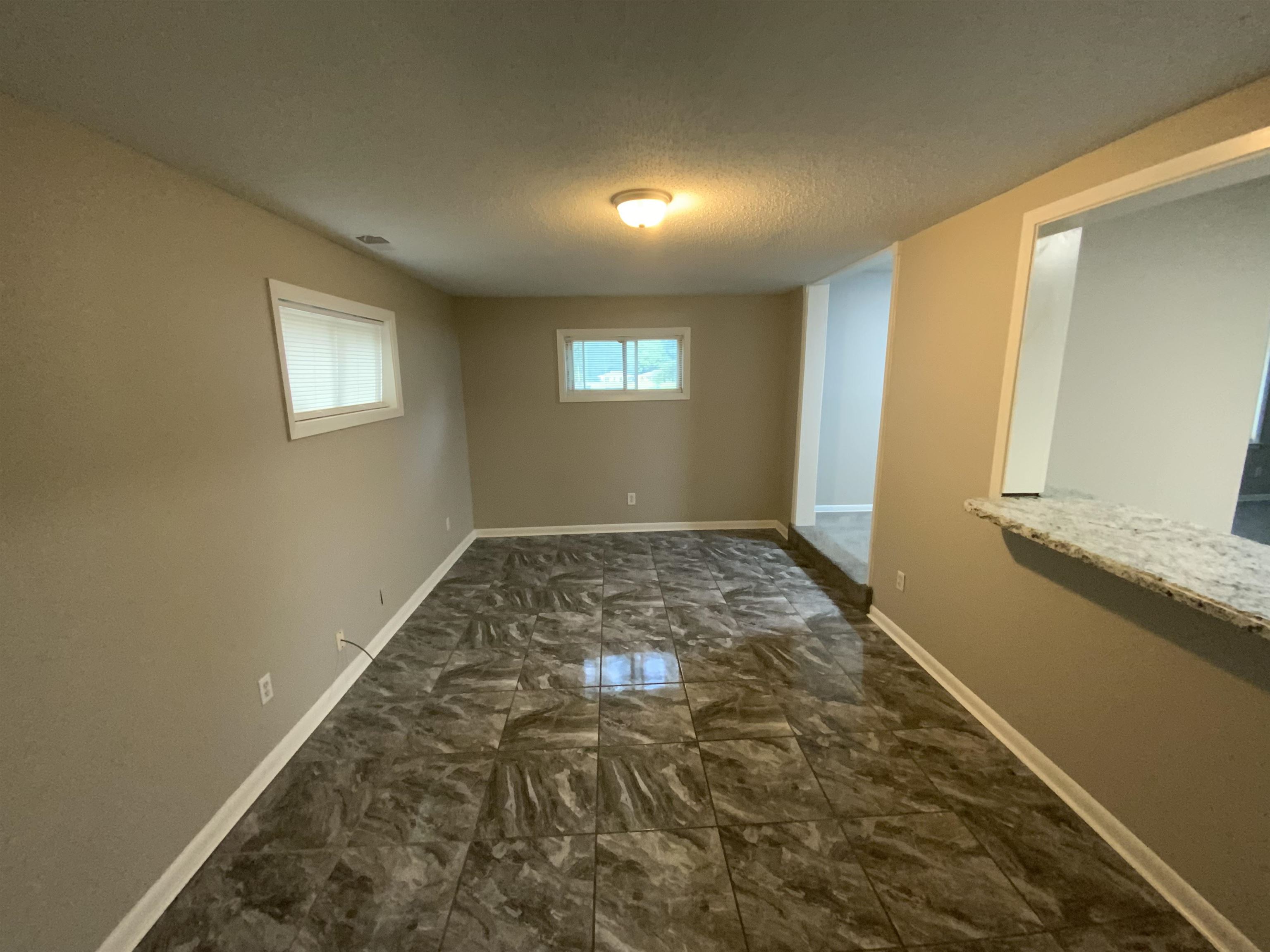 3560 Steele Street Memphis, TN 38127 - Photo 9 of 19 Empty room with marble look tile flooring and a textured ceiling