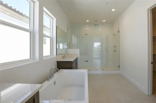 a spacious bathroom with a double vanity sink toilet mirror and bathtub