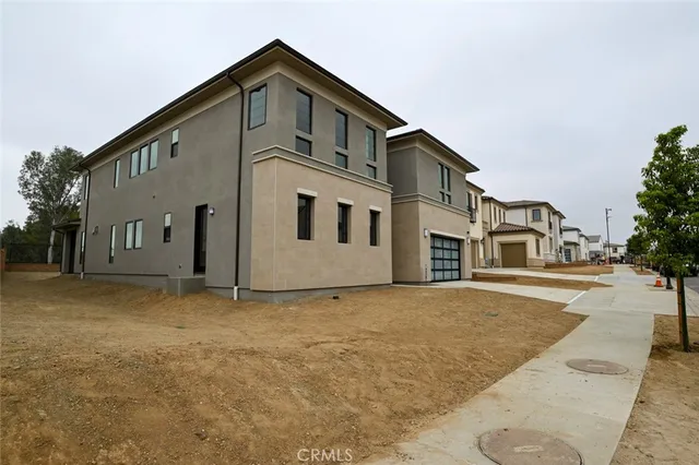 a view of a house with a yard and large tree