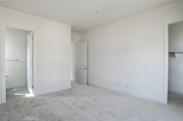 a view of an empty room with wooden floor and windows